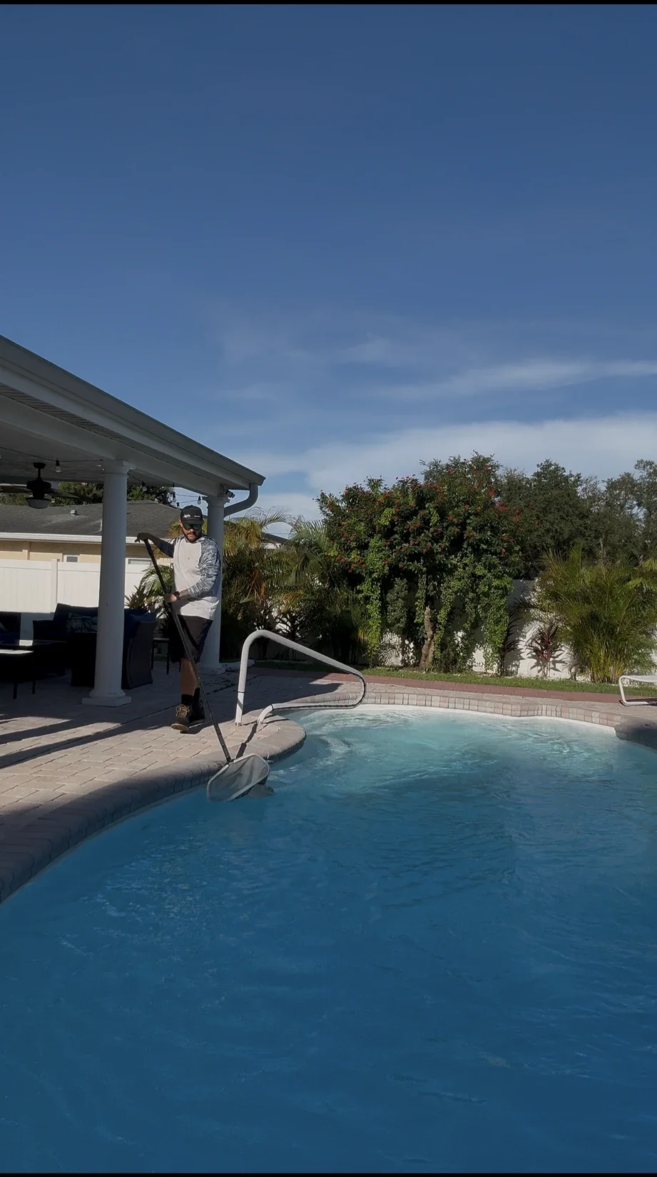 Mike Strawn, owner of Point of Pines Pools & Service, skimming a residential pool in Pinellas County FL
